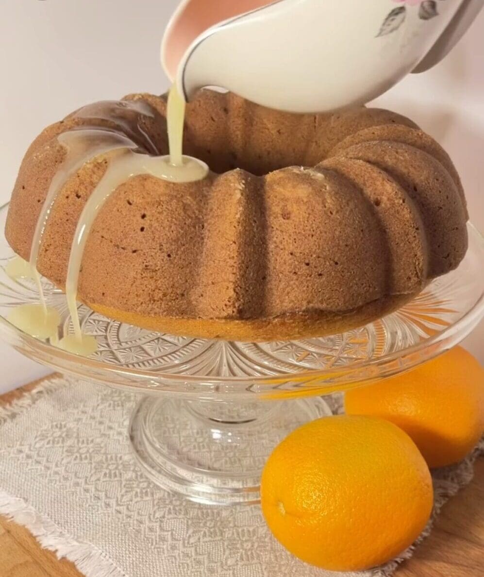 Bundt cake with glaze and fresh oranges.