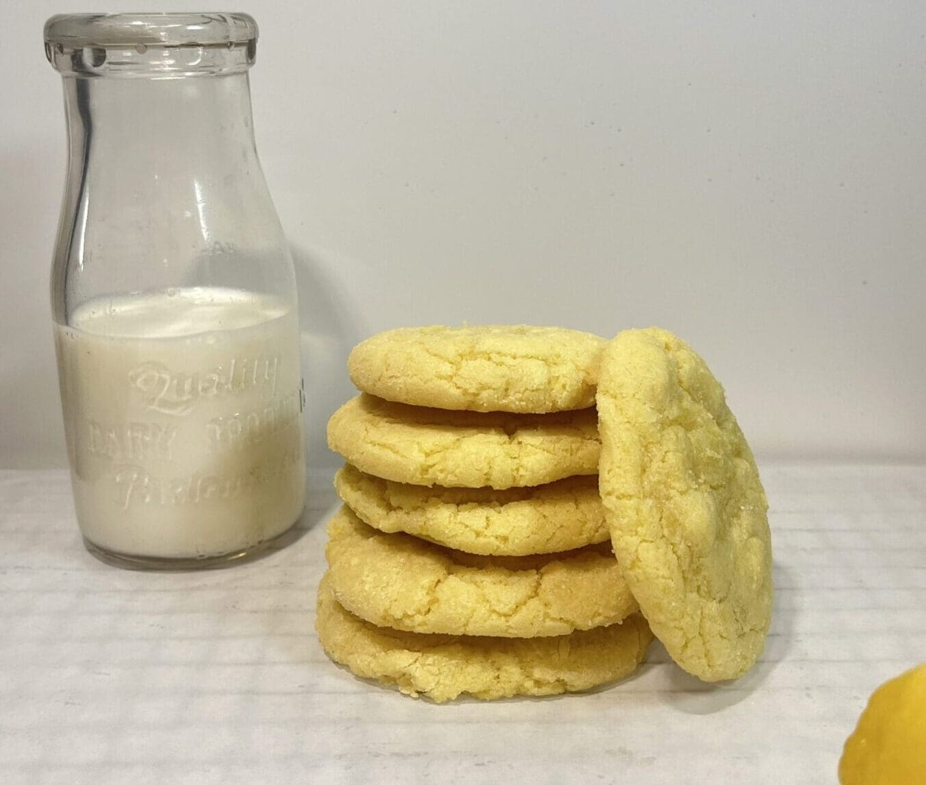 Cookies stacked beside a bottle of milk.