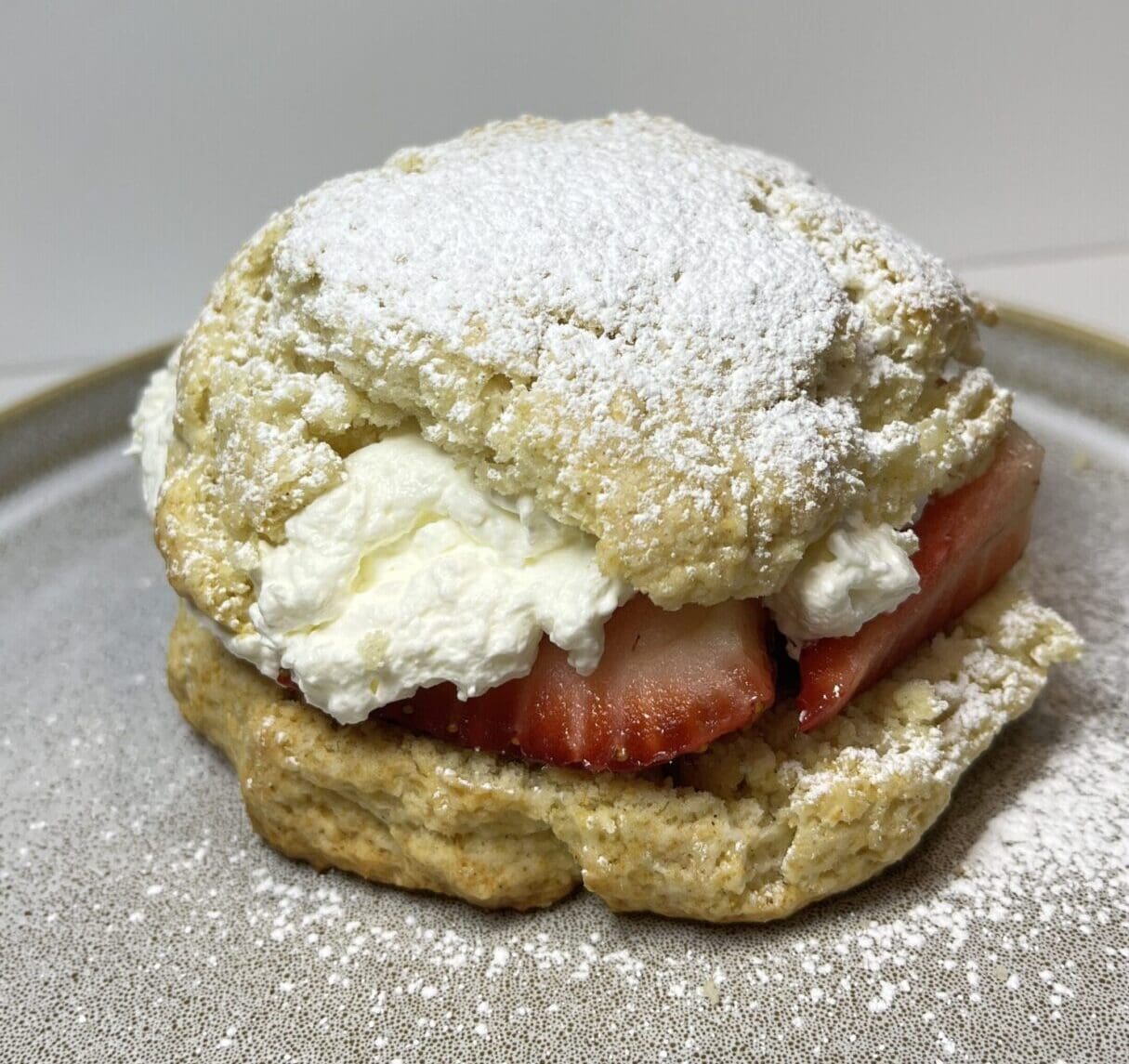 Scone with strawberries and whipped cream.