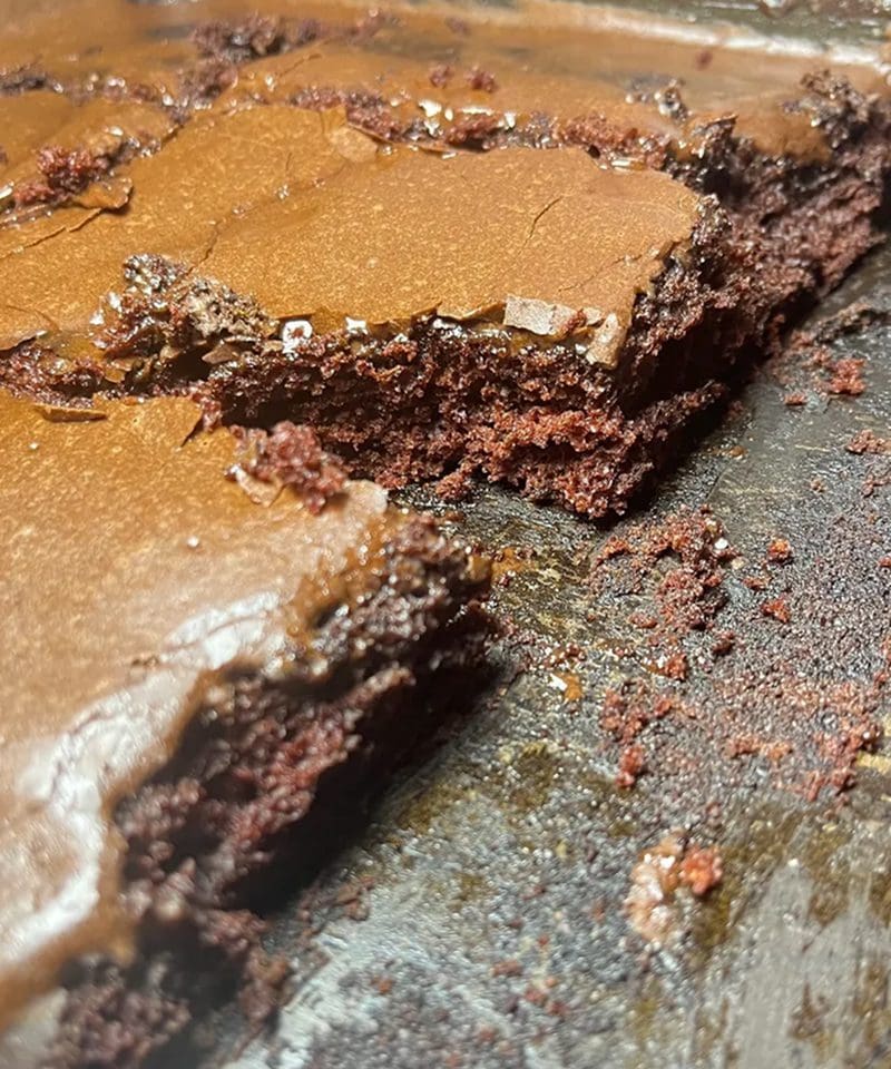 Close-up of a rich, moist chocolate cake with a piece cut out.