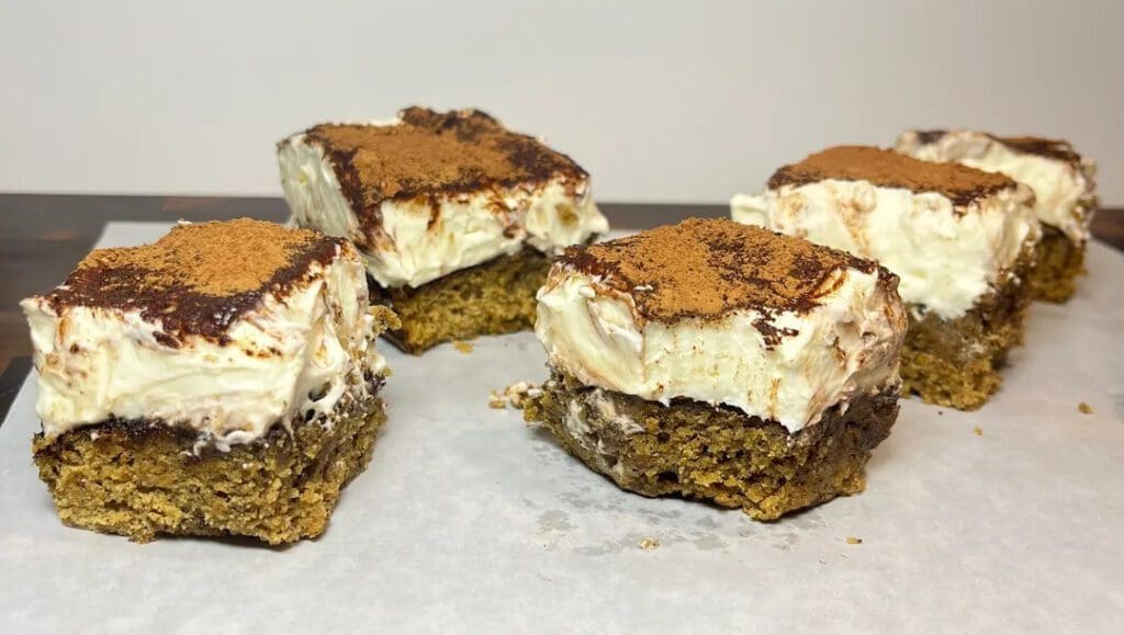 Four dessert bars with a creamy, chocolate-topped layer.
