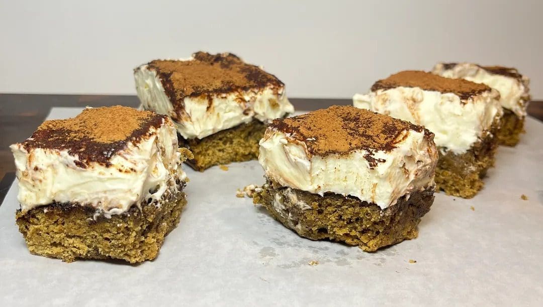Four dessert bars with a creamy, chocolate-topped layer.