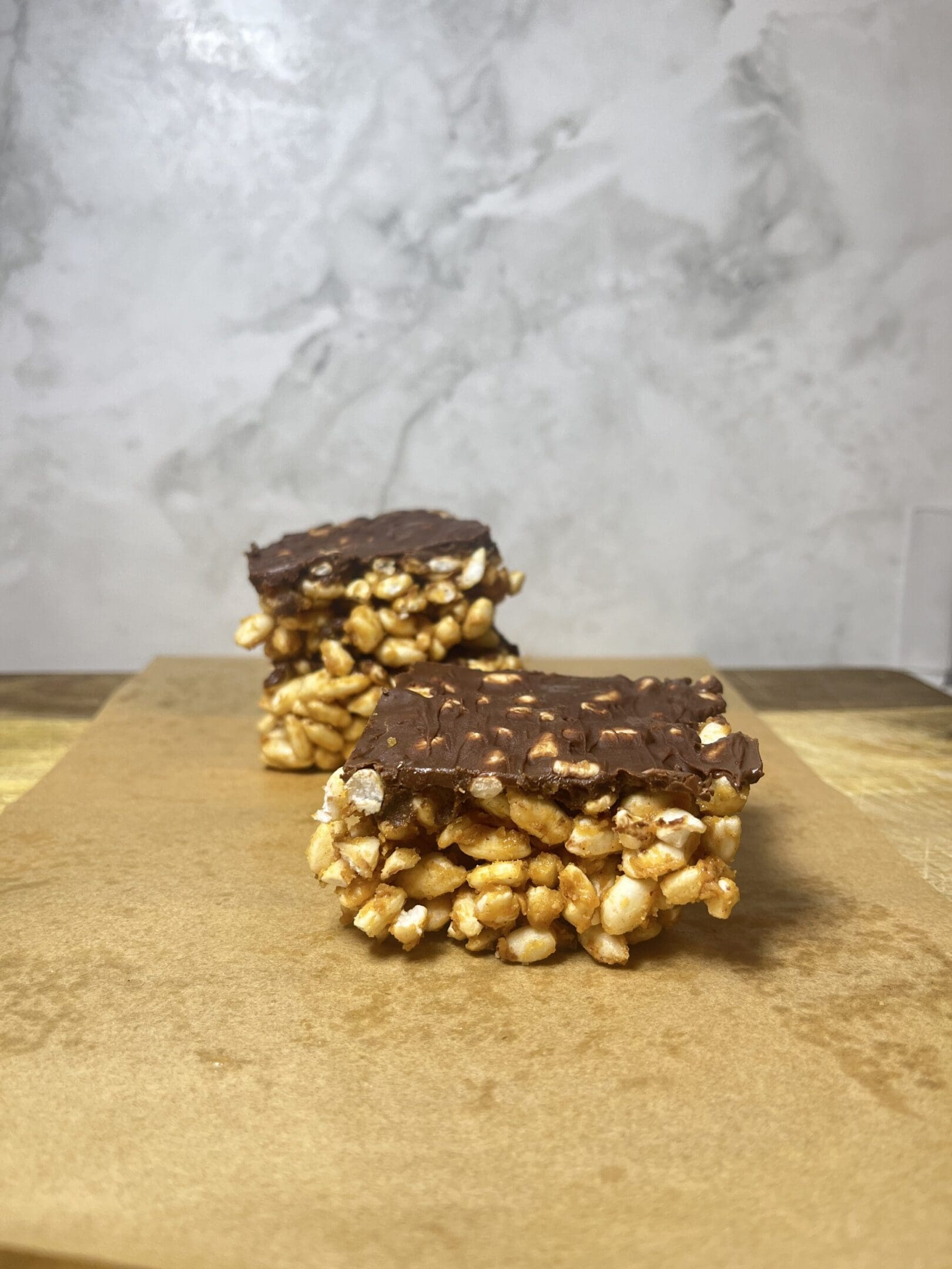 Chocolate-covered puffed rice bars on parchment.