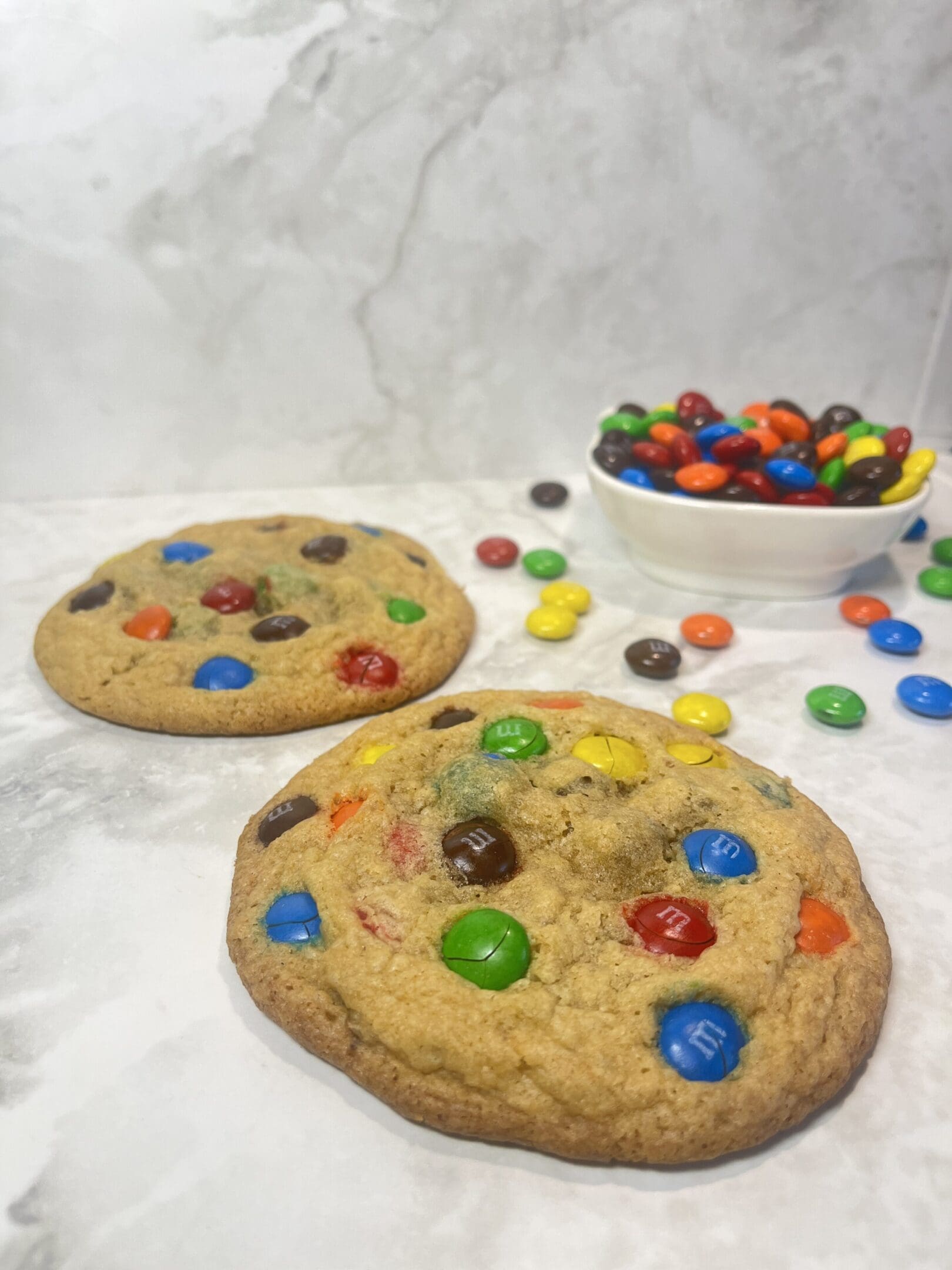 Cookies with colorful candies on marble surface.