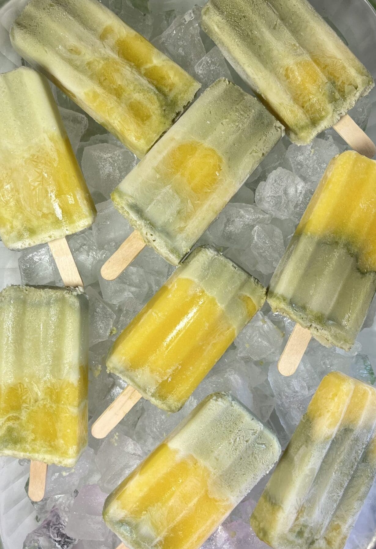 Yellow and green popsicles on ice.