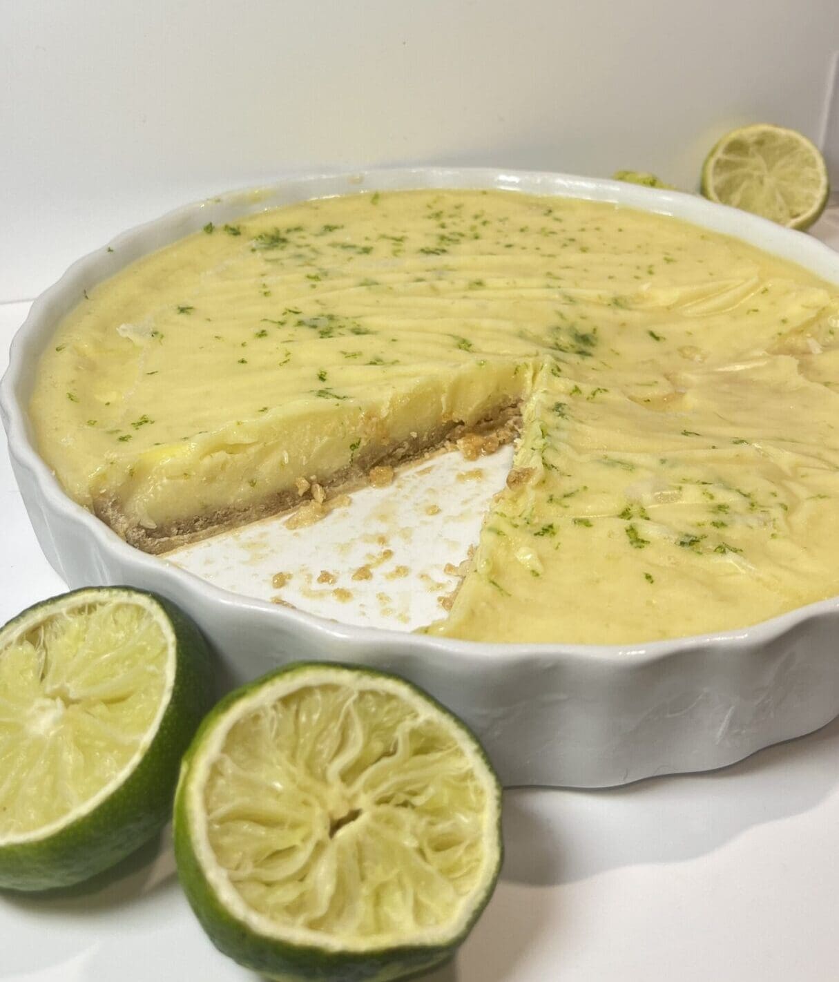 Key lime pie with fresh limes nearby.