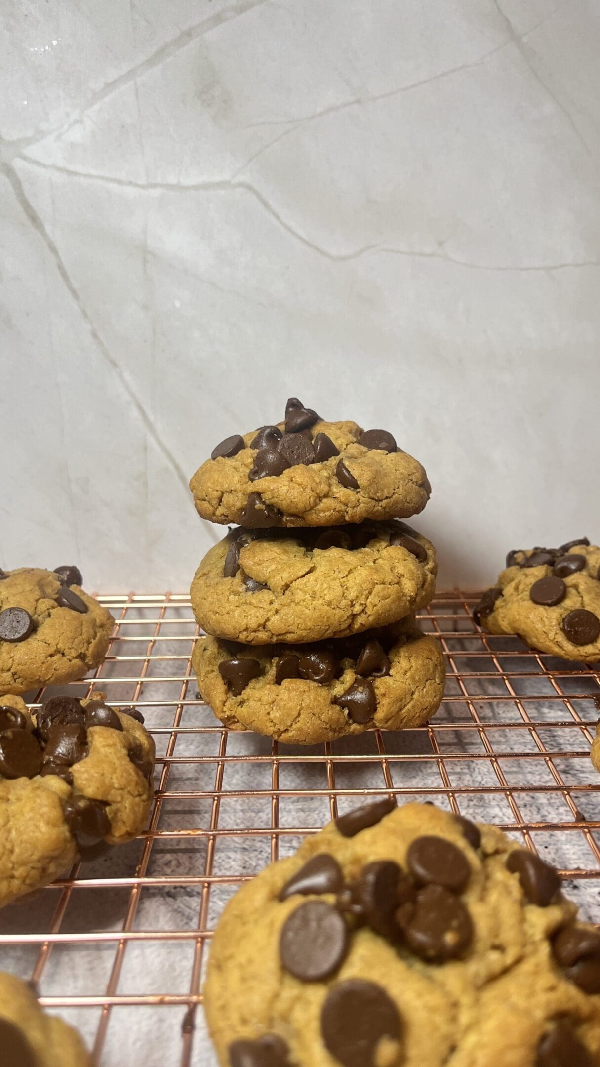 Stacked chocolate chip cookies on cooling rack.
