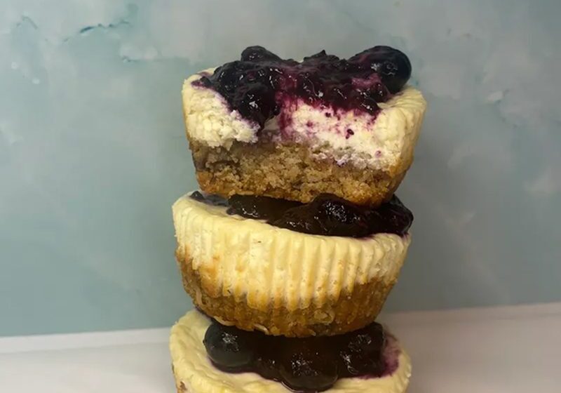 Stack of three mini cheesecakes topped with blueberries.