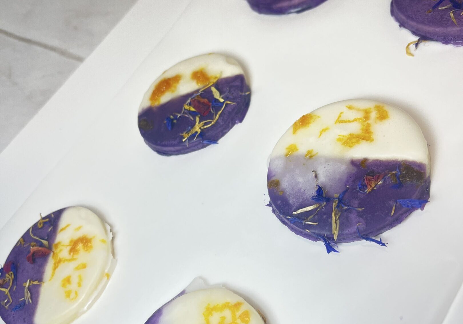 Purple and white handmade soaps with flowers.