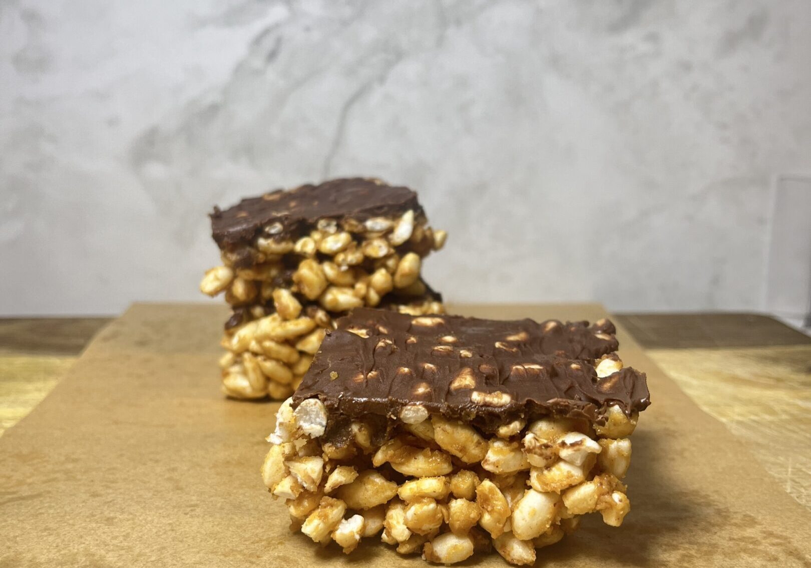 Chocolate-covered puffed rice bars on parchment.