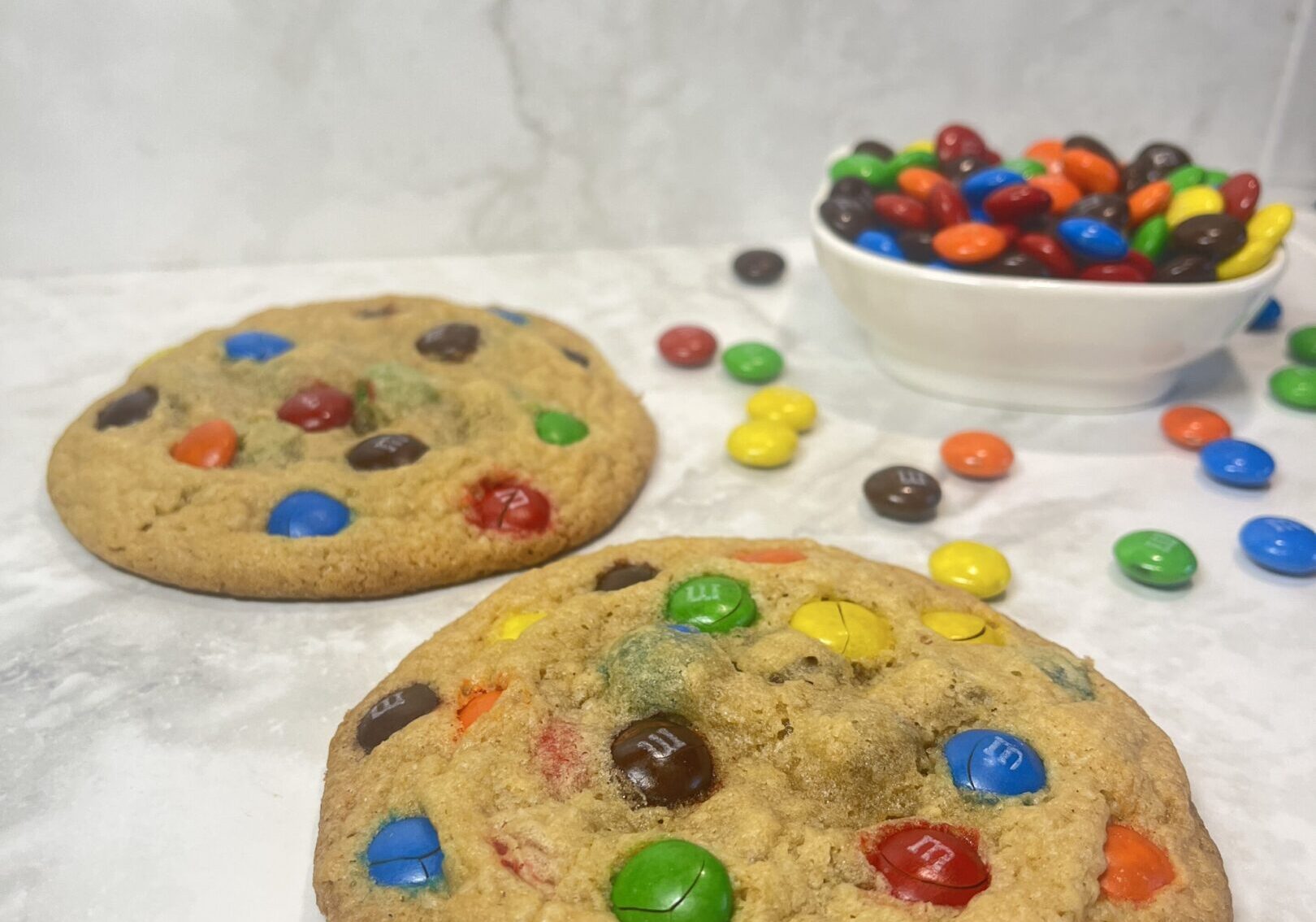 Cookies with colorful candies on marble surface.
