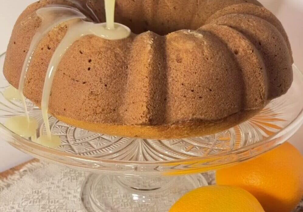 Bundt cake with glaze and fresh oranges.