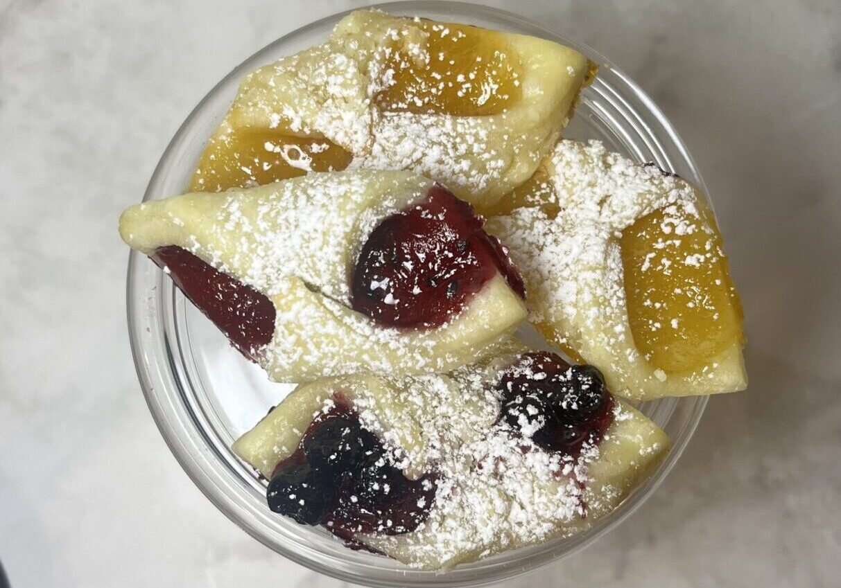 Pastries with fruit fillings and powdered sugar.