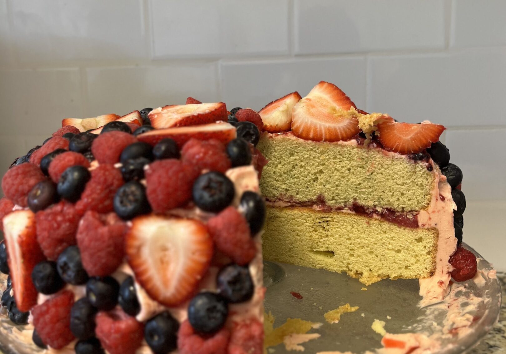 Cake with berries on a glass stand.