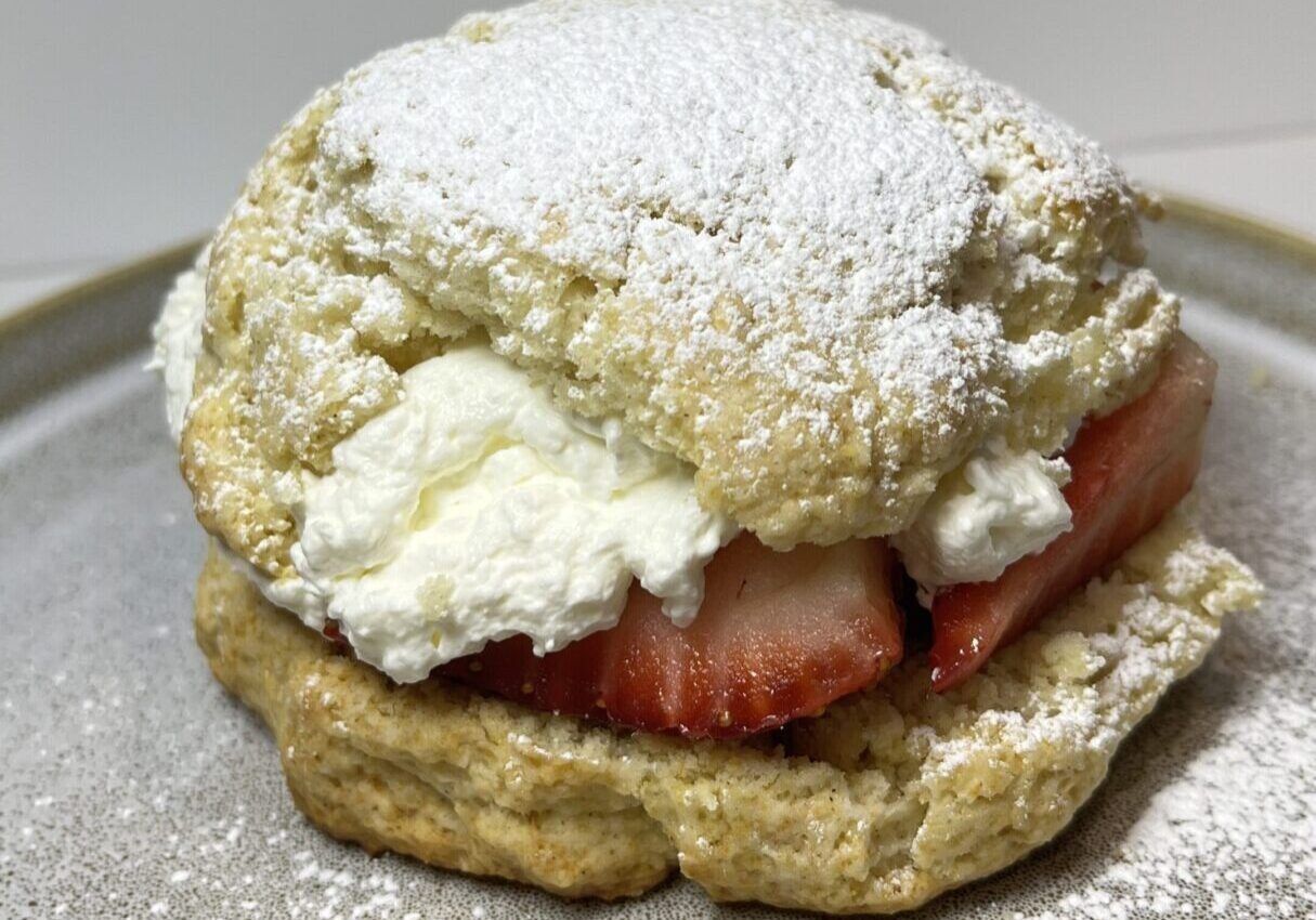 Scone with strawberries and whipped cream.