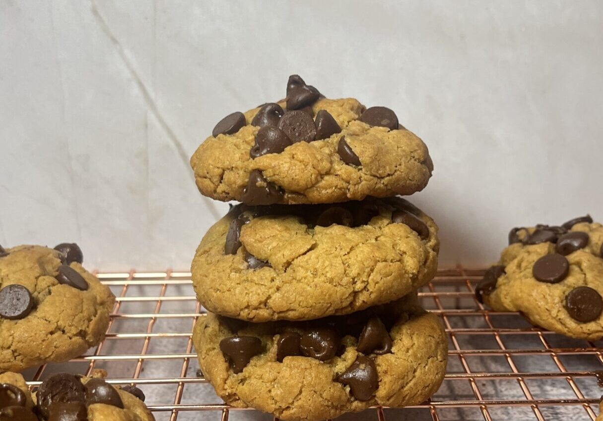 Stacked chocolate chip cookies on cooling rack.