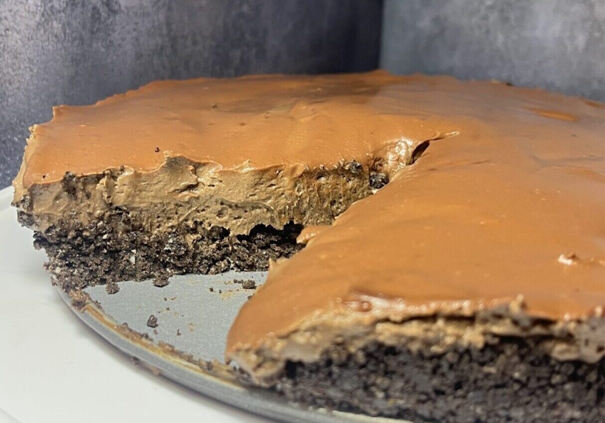 Chocolate cheesecake with a slice removed.