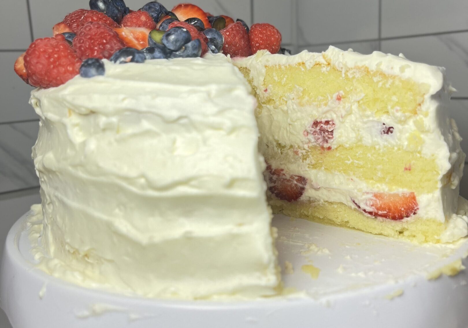 Layered cake with berries on top.